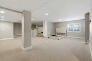 Below grade area with light colored carpet and recessed lighting