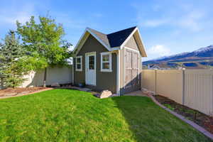 View of shed with a fenced backyard and a mountain view