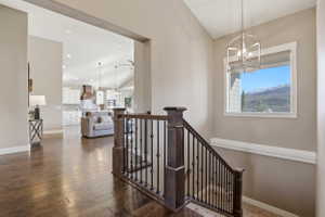 Stairs featuring hardwood / wood-style flooring, healthy amount of natural light, suspended lighting, and a high ceiling