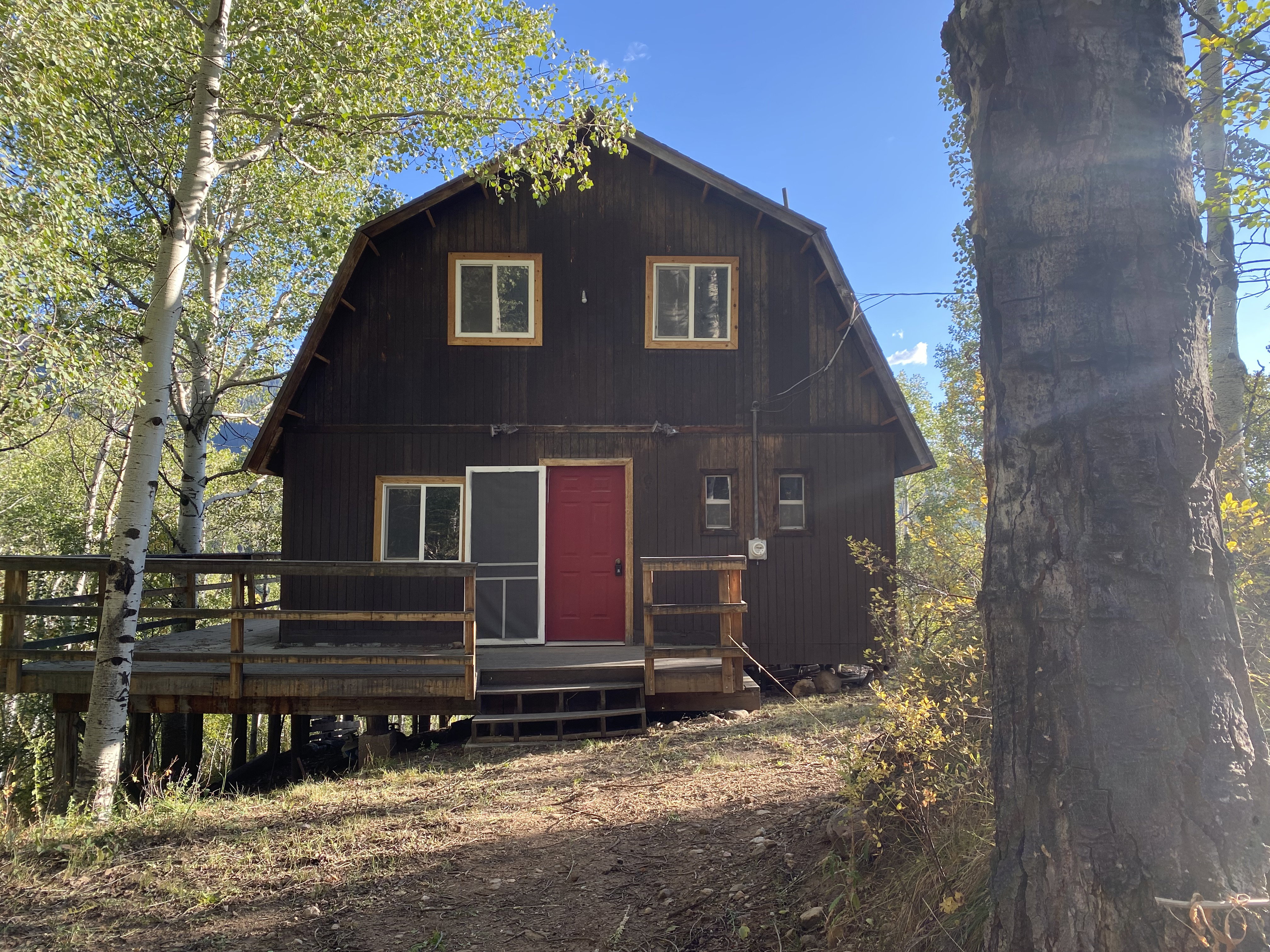 View of front of property with a deck and a gambrel roof