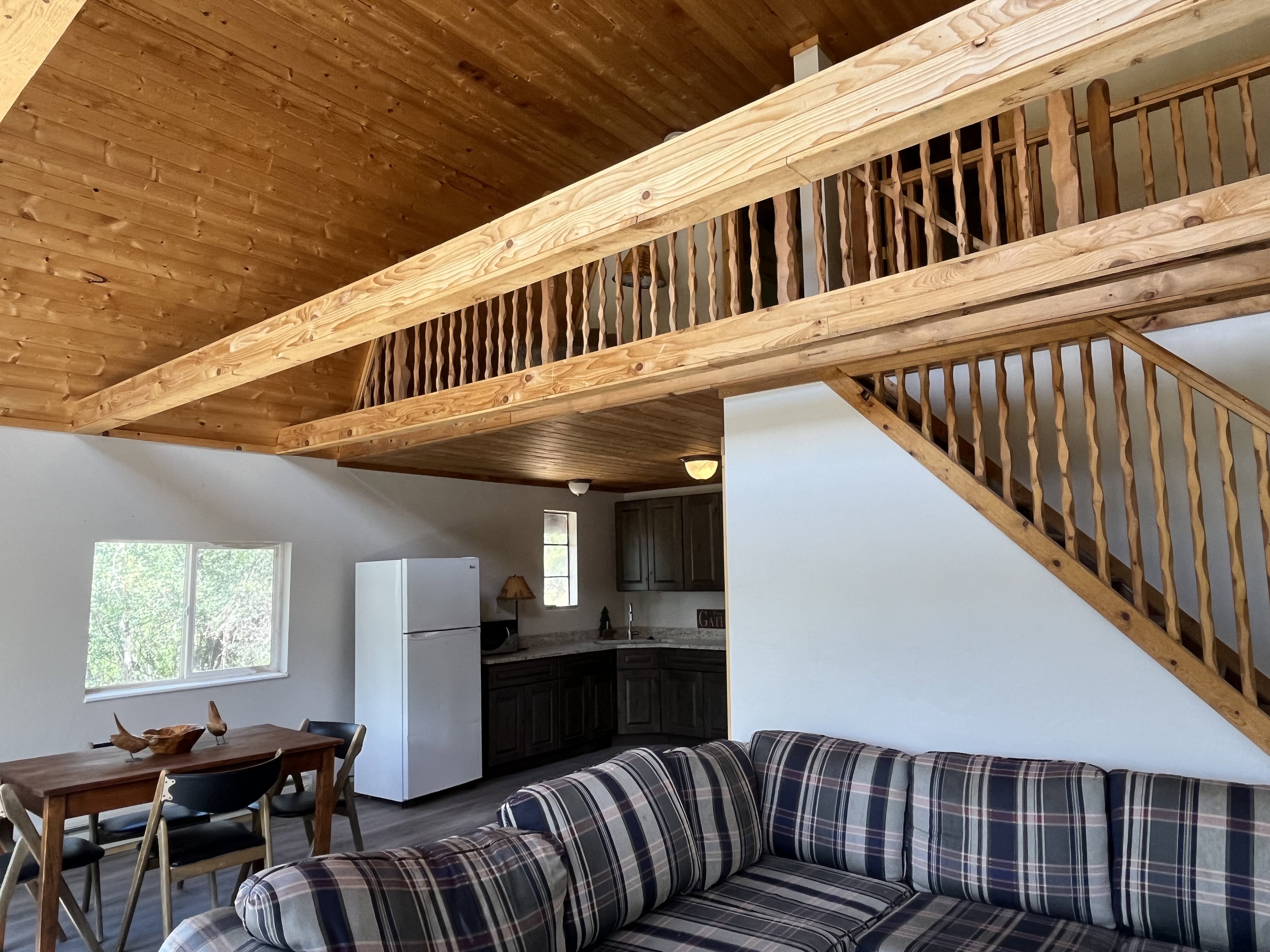 Great room with vaulted ceiling and loft space above.