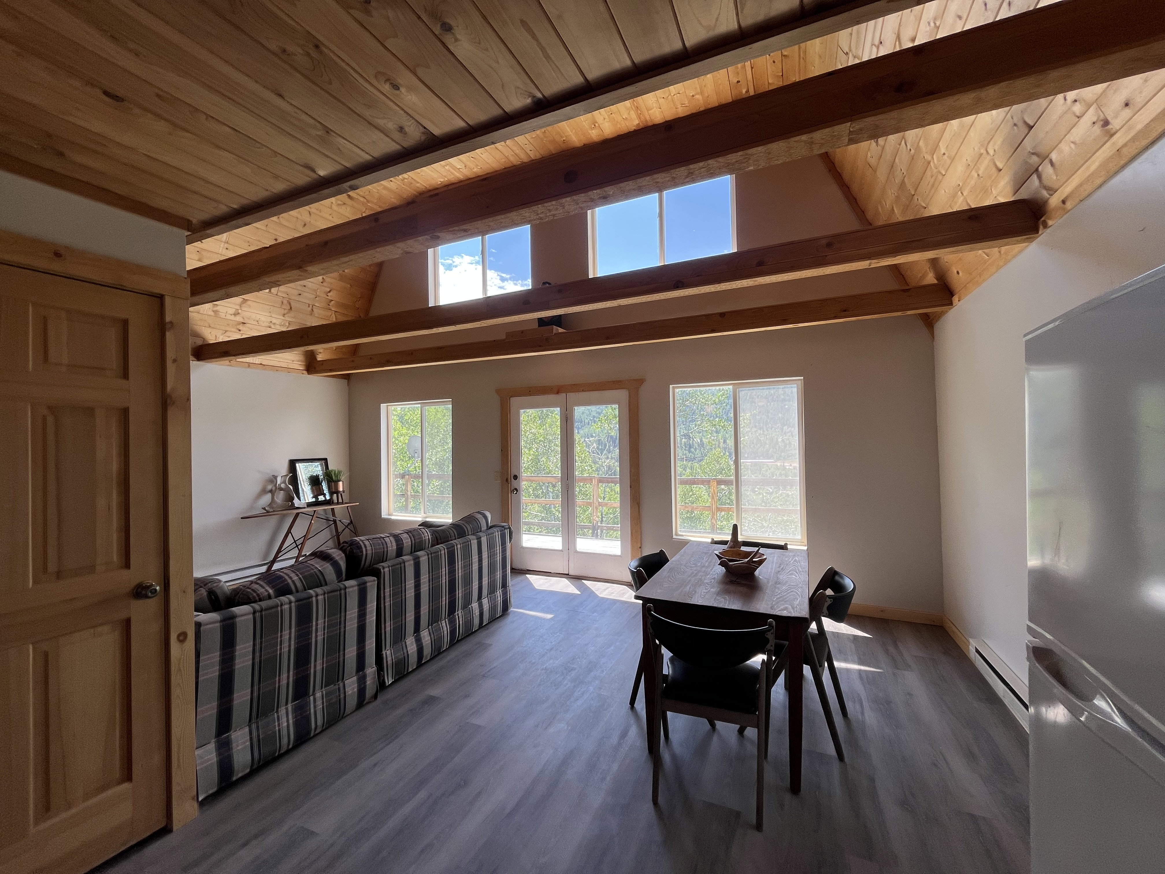 Dining area with french doors, wood-type flooring, a baseboard heating unit, and a high wood beamed ceiling