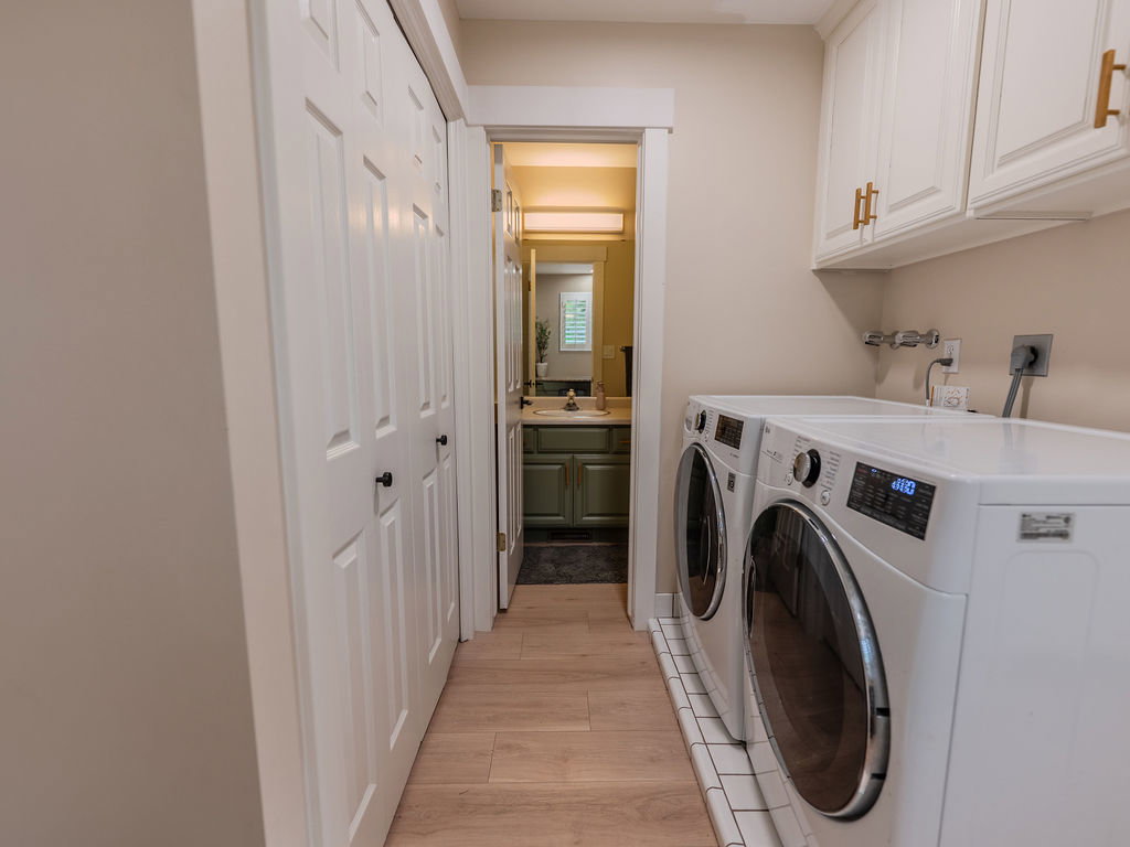Laundry room with light wood-type flooring, cabinet space, and washing machine and dryer