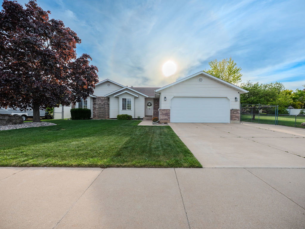 Ranch-style home featuring brick siding, concrete driveway, and an attached garage