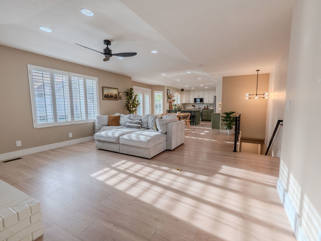 Living area featuring ceiling fan, light wood-style flooring, and recessed lighting