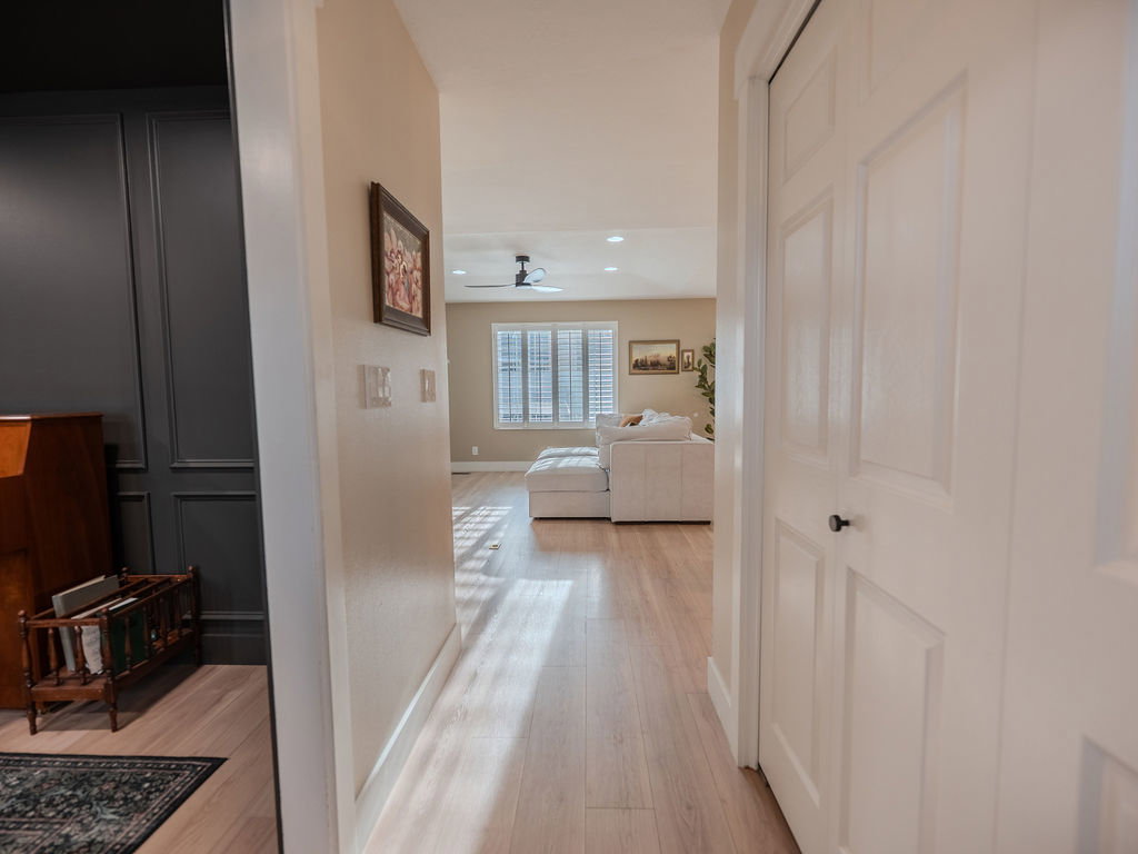 Hallway with light wood finished floors and recessed lighting