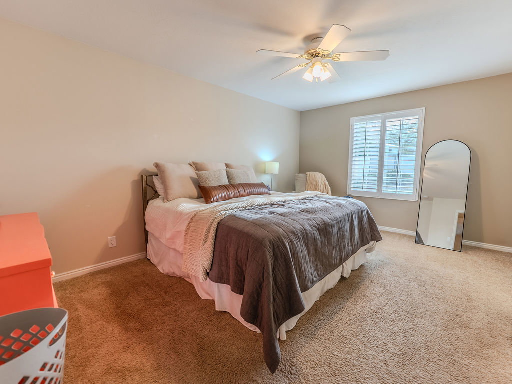 Bedroom featuring ceiling fan and light carpet