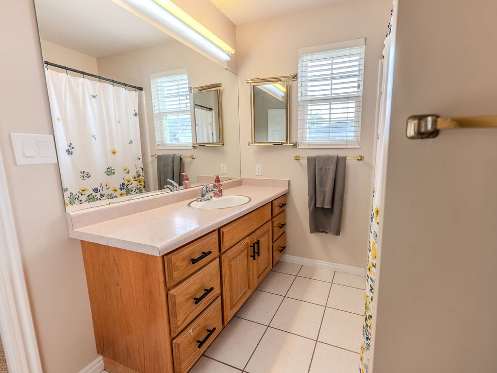 Bathroom featuring vanity, a shower with curtain, and light tile patterned floors