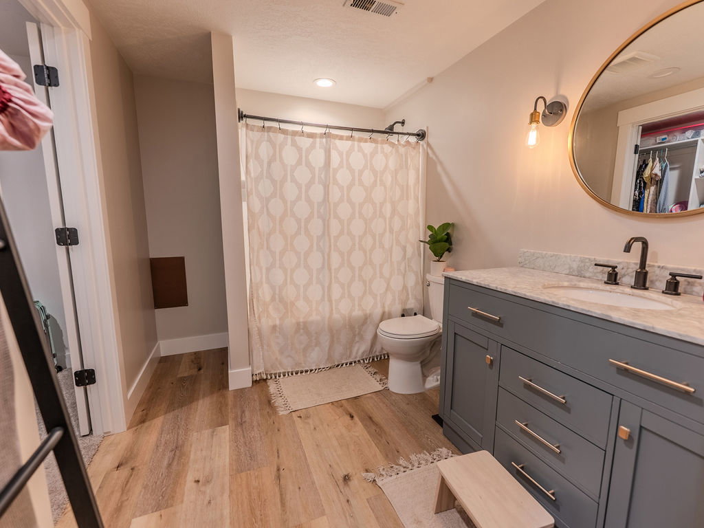 Full bath featuring vanity and light wood-style flooring