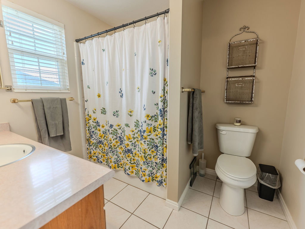 Full bath with vanity, curtained shower, and light tile patterned flooring