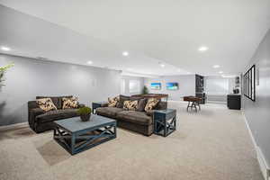 Fully finished lower level is designed for hosting in style, with a massive gathering room including ample space for a pool table, stone accent wall, built-in media wall, and a sleek kitchenette