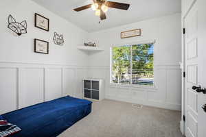 Large bedroom featuring a ceiling fan and custom wood work.