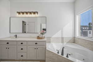 The spa-inspired bath features an oversized, newly tiled shower, a corner jetted tub, quartz countertops, a private water closet, and a spacious walk-in closet