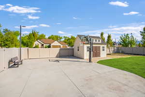 Fully fenced back yard with basketball hoop, shed and outdoor lighting