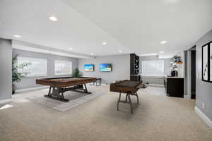 Fully finished lower level is designed for hosting in style, with a massive gathering room including ample space for a pool table, stone accent wall, built-in media wall, and a sleek kitchenette