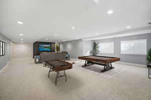 Fully finished lower level is designed for hosting in style, with a massive gathering room including ample space for a pool table, stone accent wall, built-in media wall, and a sleek kitchenette