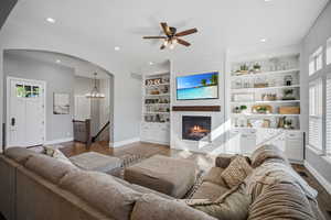 Open great room with a wall of windows overlooking the back yard.  Custom built ins and shiplap fireplace