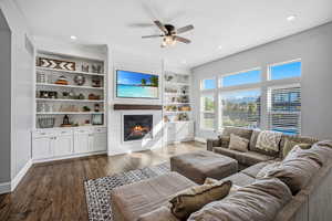 Open great room with a wall of windows overlooking the back yard.  Custom built ins and shiplap fireplace