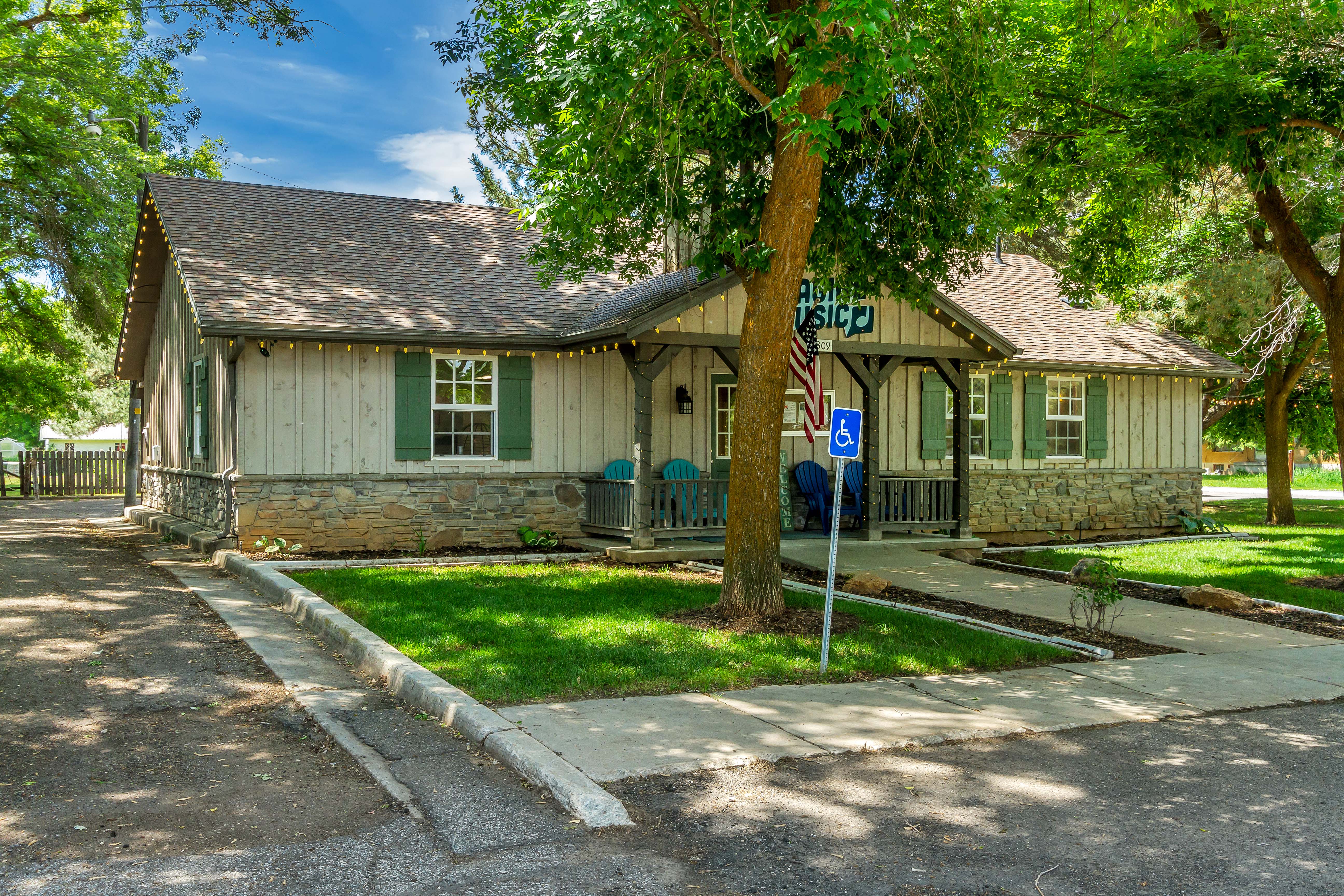 View of front of property featuring stone siding, roof with shingles, a porch, and board and batten siding