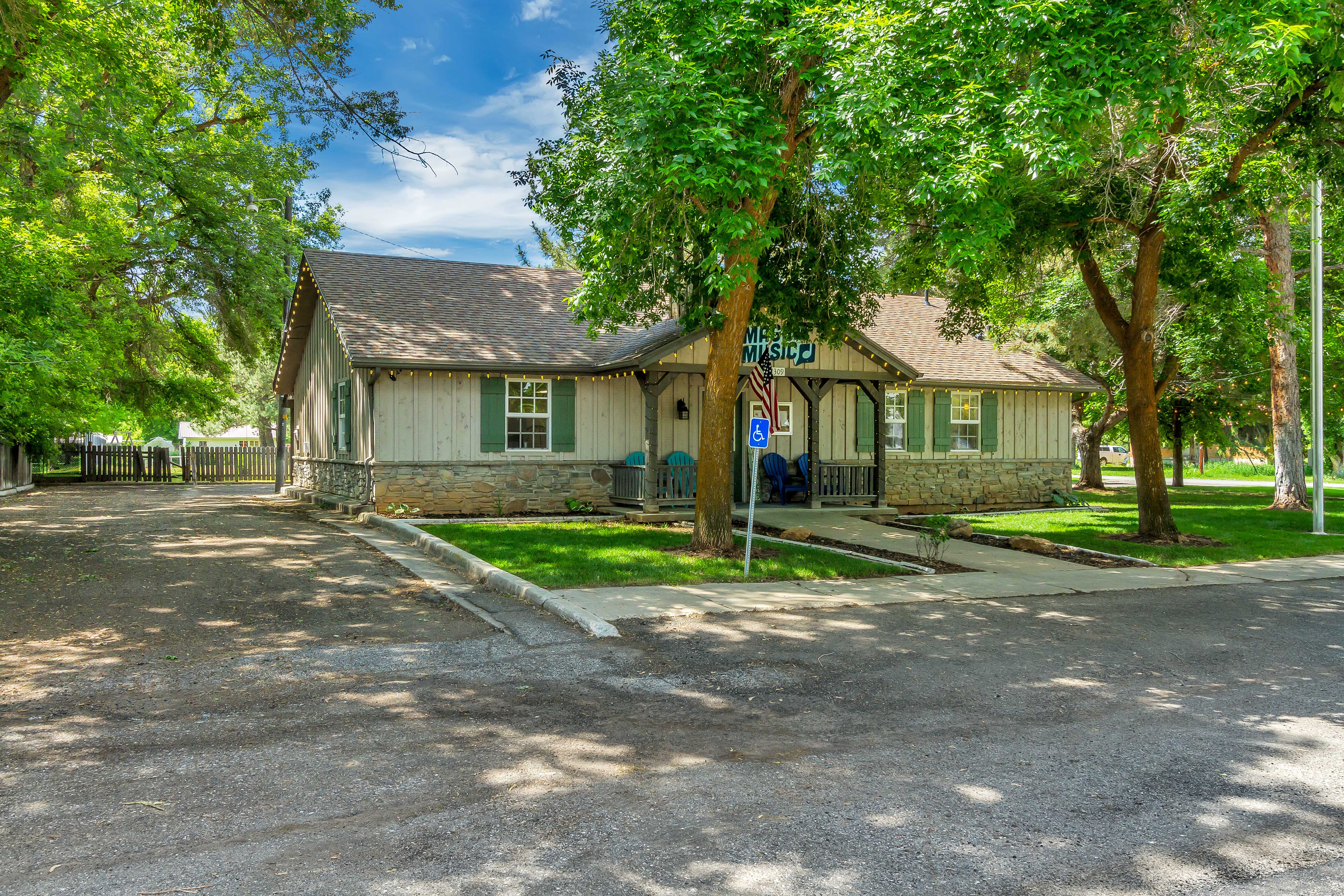 View of front of property with stone siding, a shingled roof, and board and batten siding