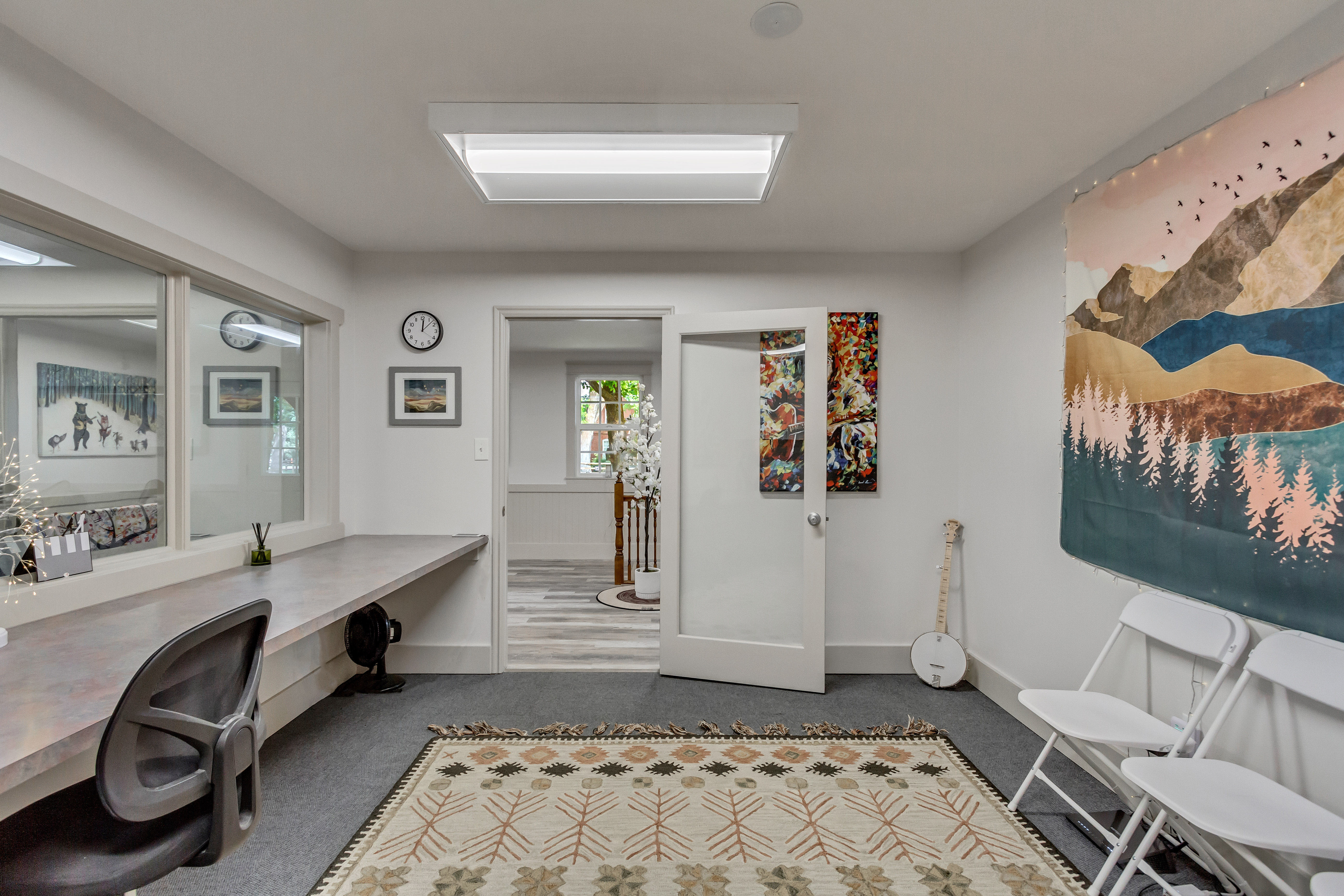 Office with dark colored carpet and baseboards