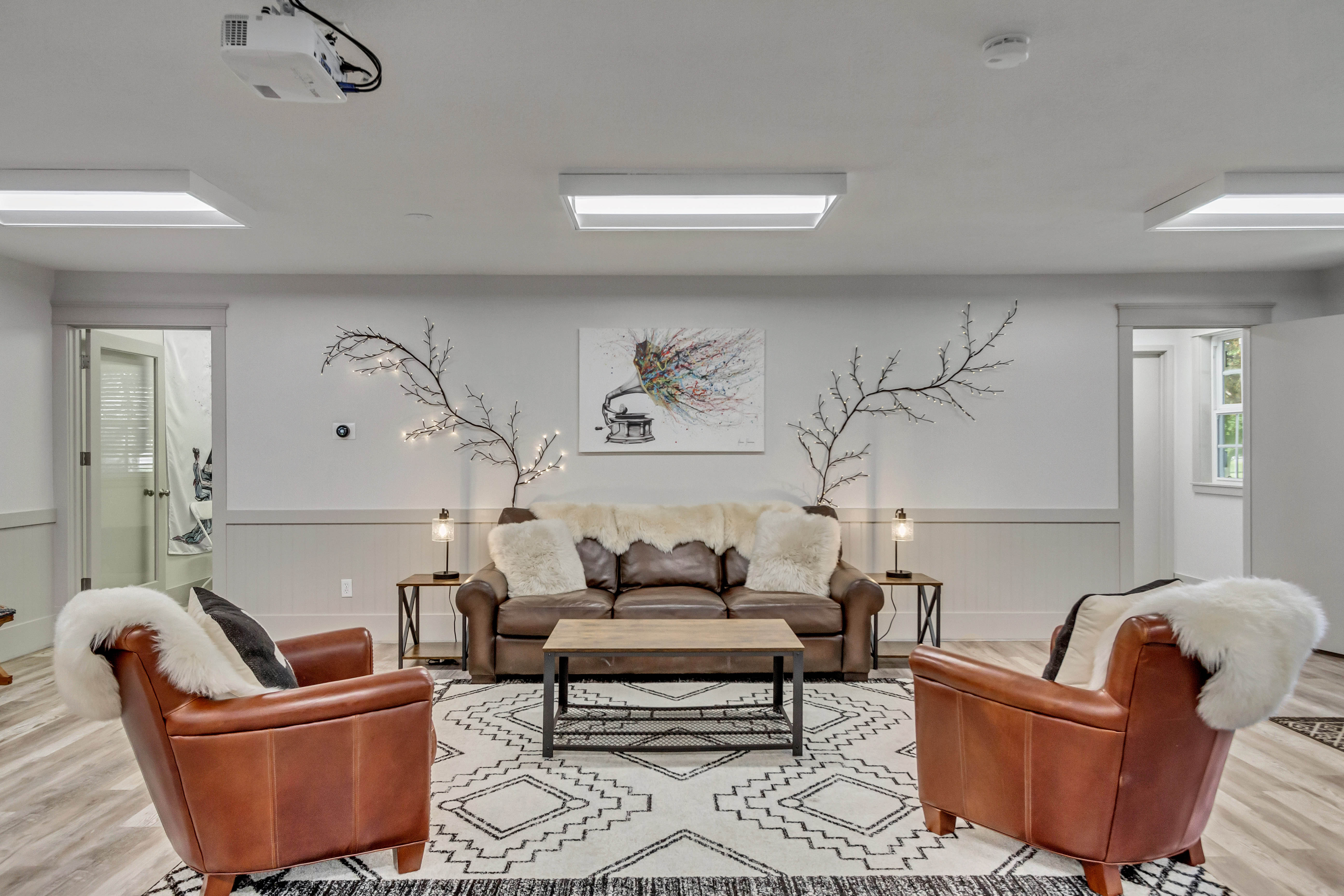 Living area featuring light wood finished floors and a wainscoted wall