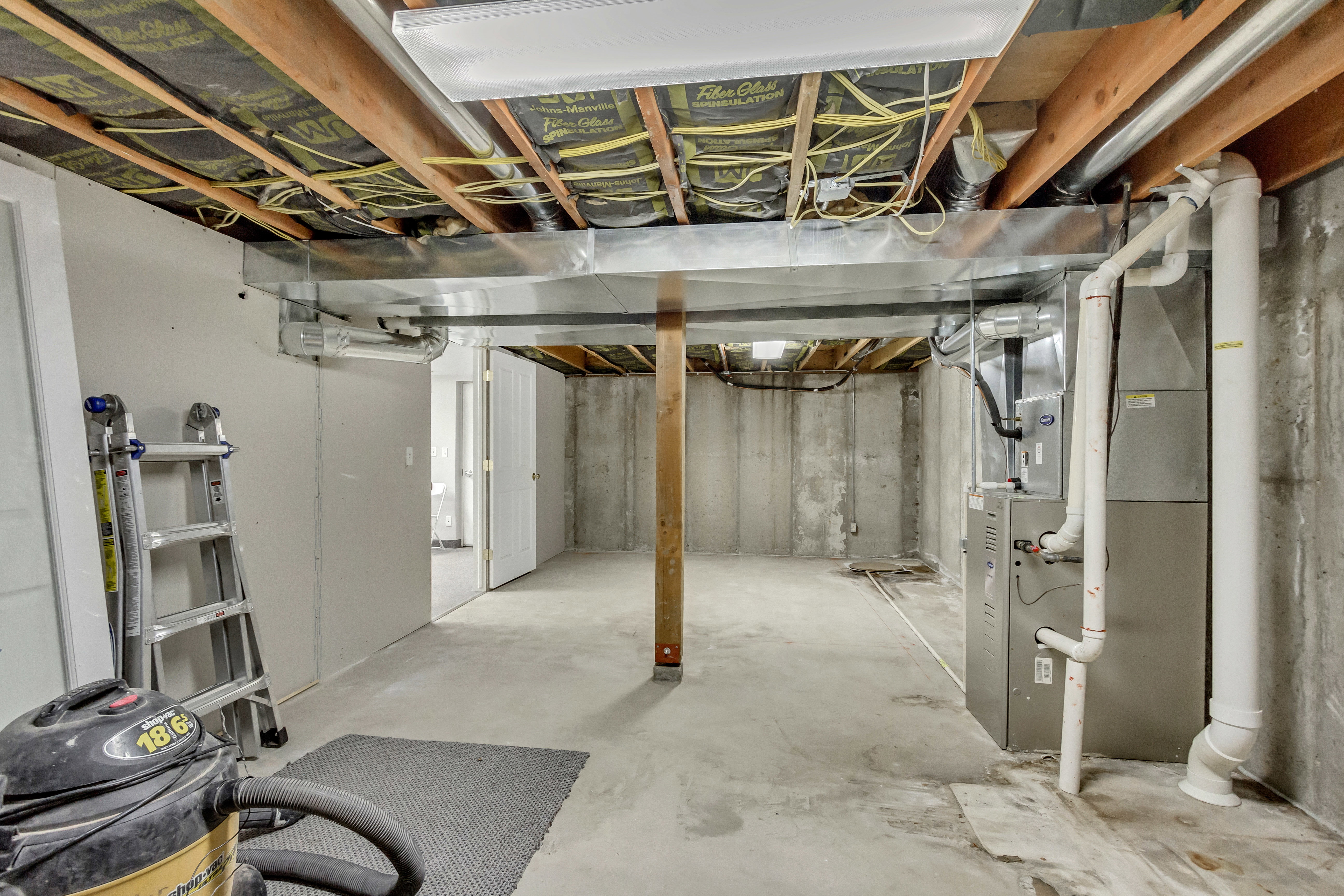 Unfinished below grade area featuring heating unit