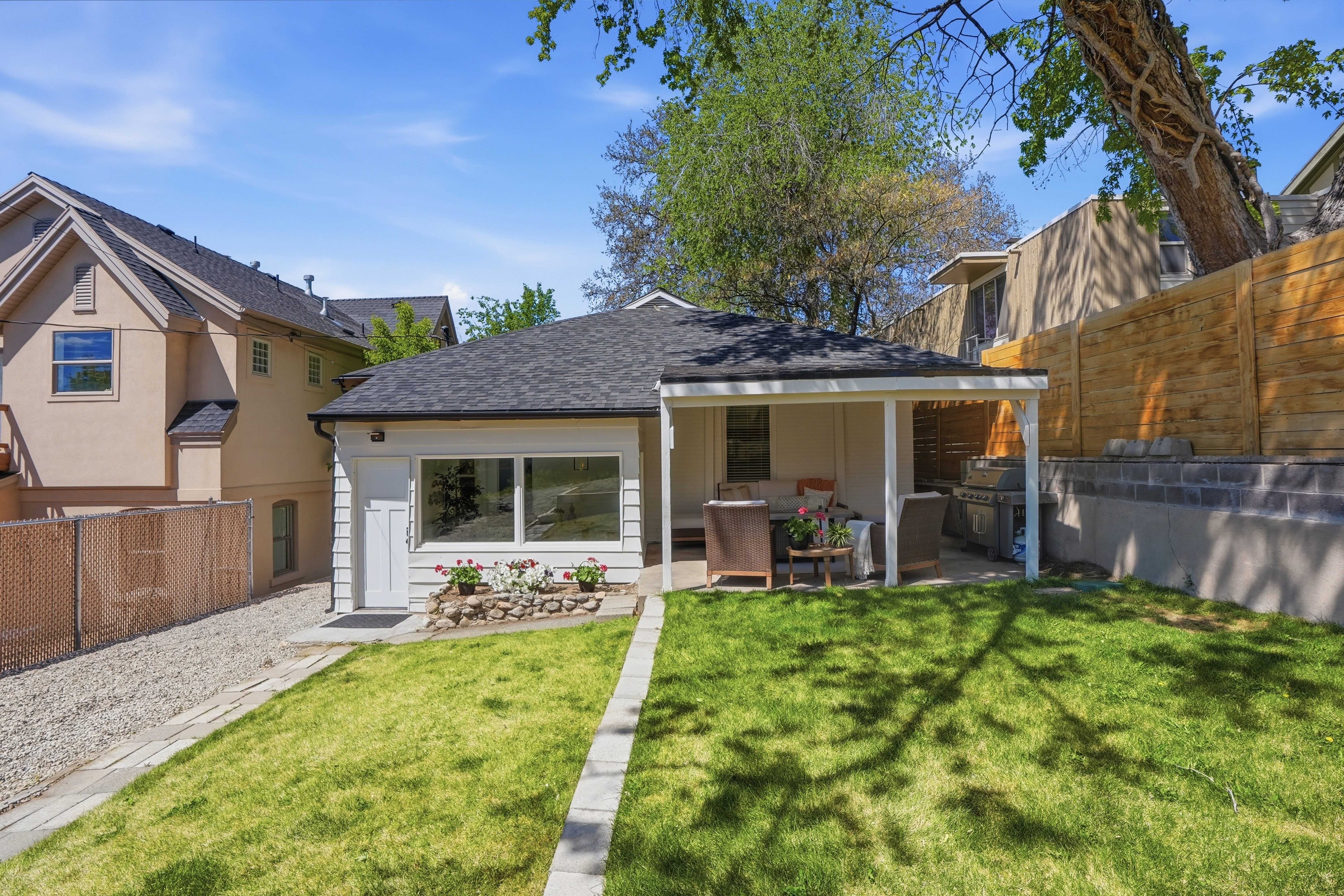 Back of house featuring a fenced backyard, a shingled roof, and a patio area
