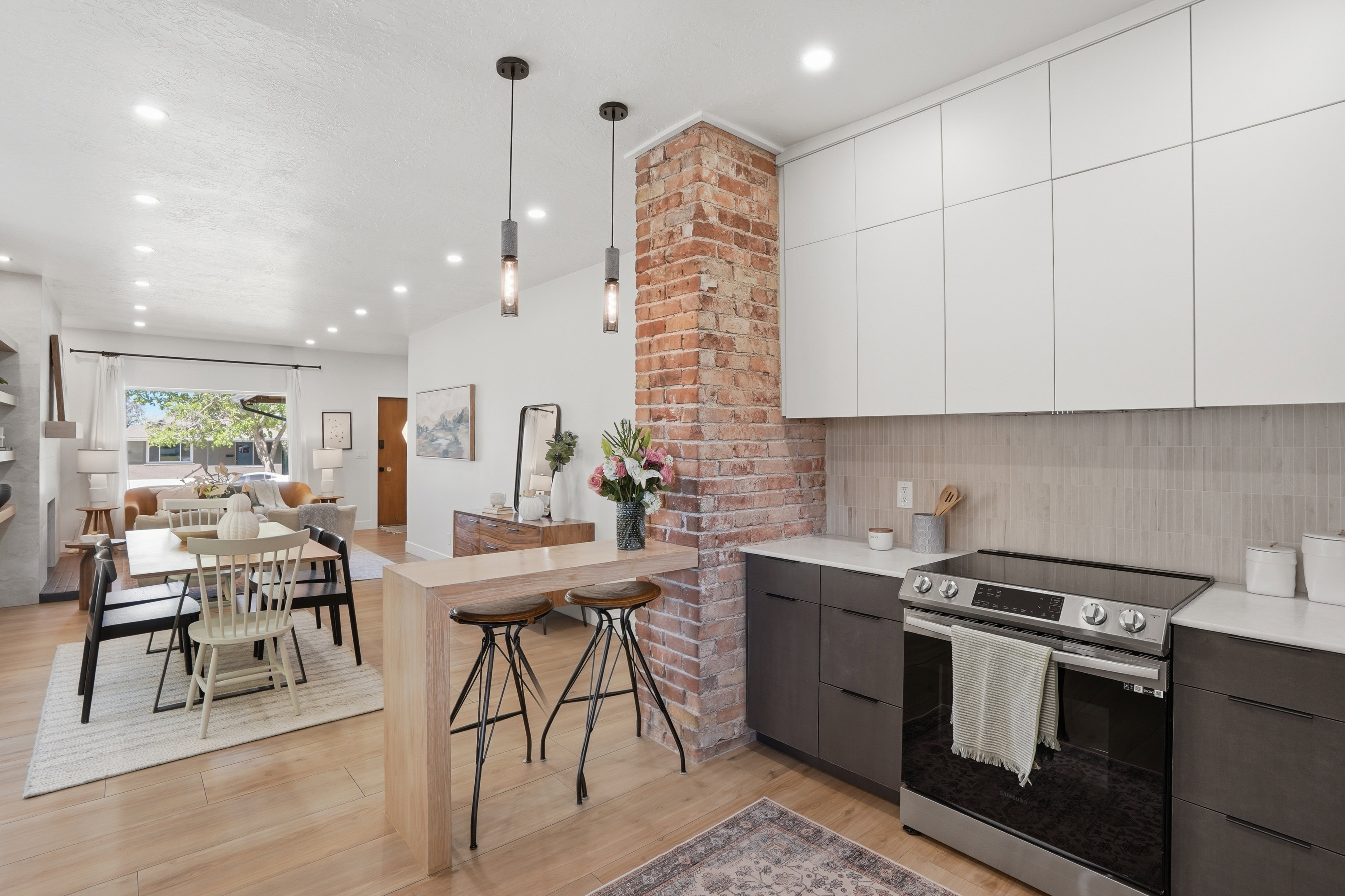 Kitchen with electric stove, marble countertops, pendant lighting, and open floor plan