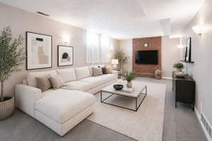 Carpeted living room featuring a textured ceiling
