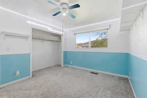 Unfurnished bedroom with carpet floors, a ceiling fan, and a closet