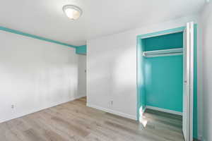 Unfurnished bedroom featuring light wood-type flooring and a closet