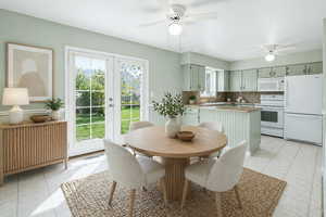 Dining space featuring a ceiling fan, french doors, and light tile patterned floors