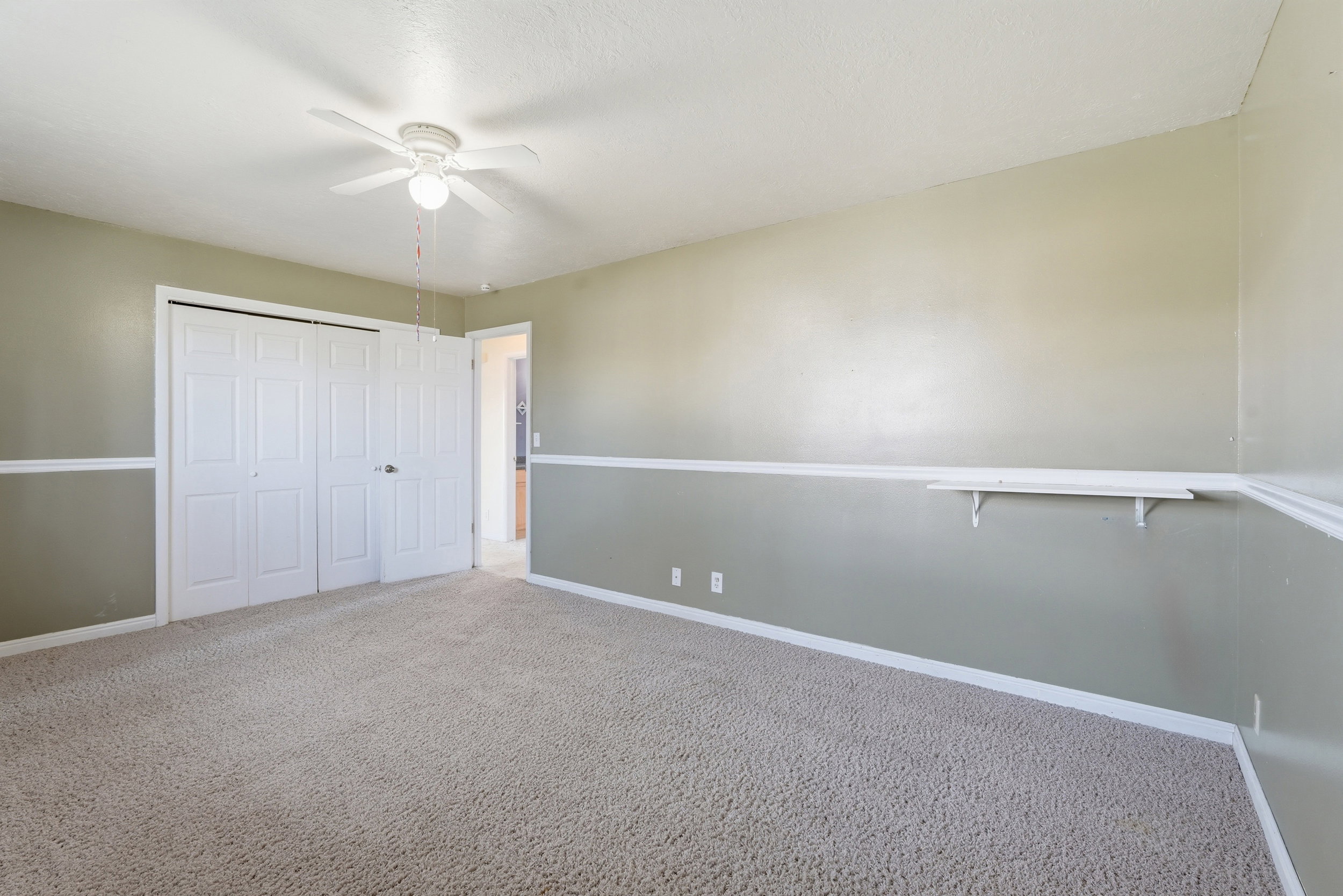 Unfurnished bedroom featuring carpet, a closet, and a ceiling fan
