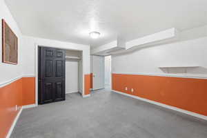 Finished below grade area featuring carpet and a textured ceiling
