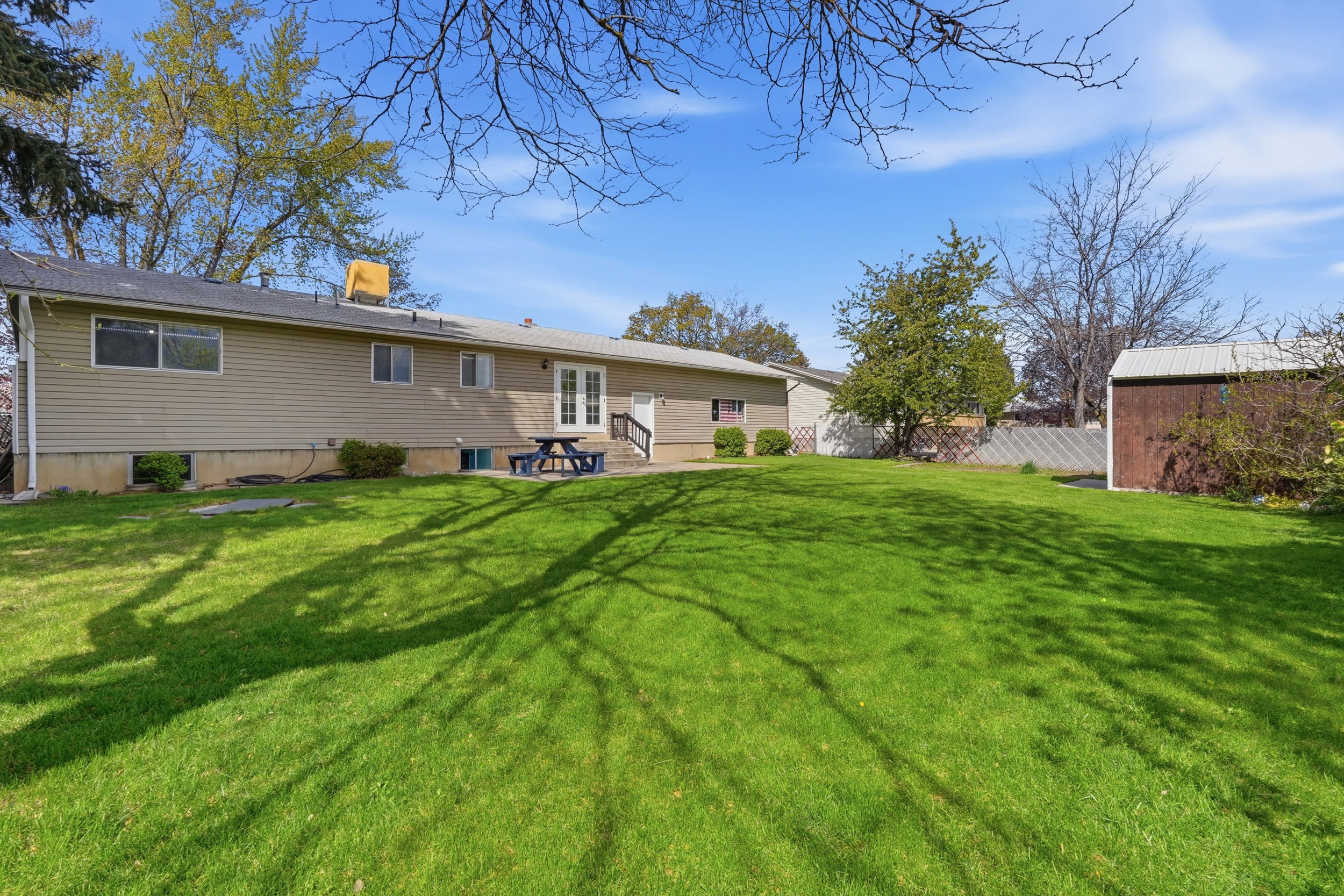 Back of property featuring a patio and a storage unit