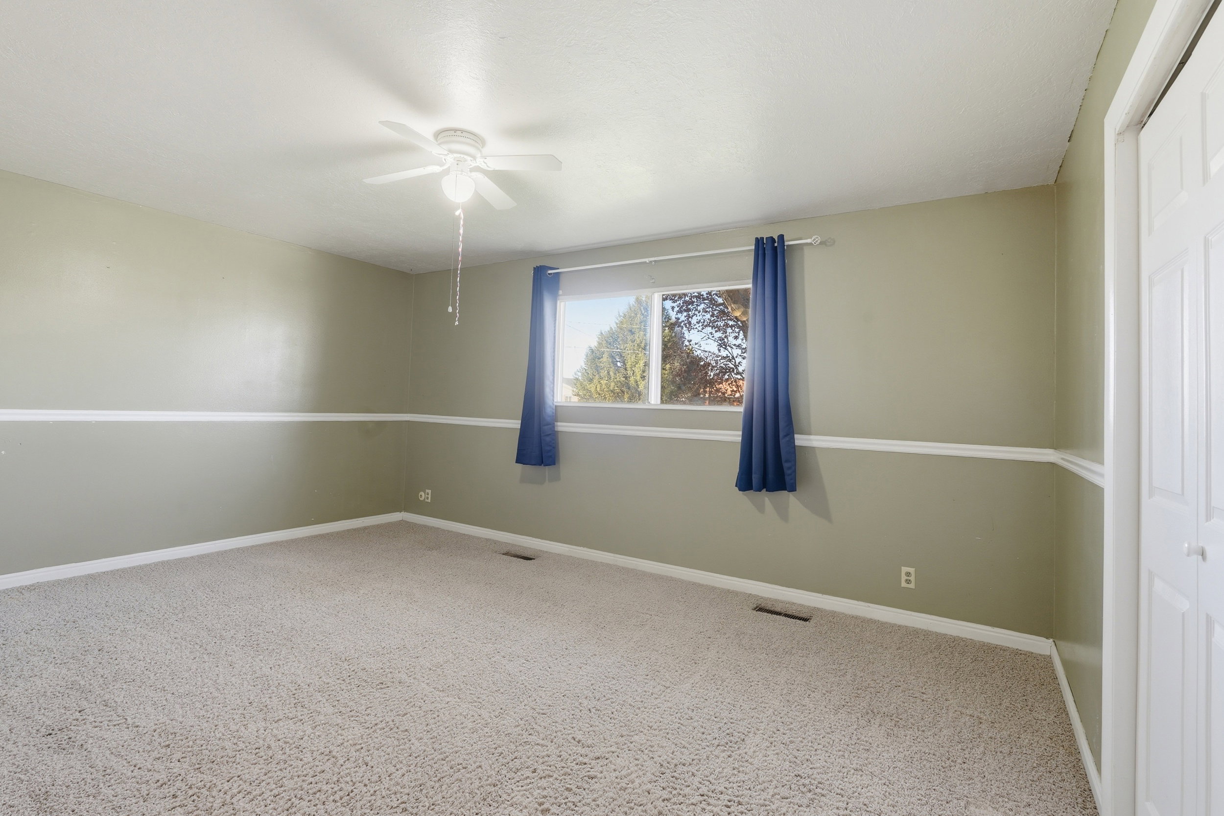 Unfurnished room with light carpet and a ceiling fan