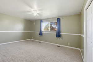 Unfurnished room with light carpet and a ceiling fan
