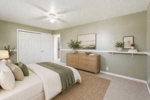 Bedroom with light colored carpet, a closet, and a ceiling fan