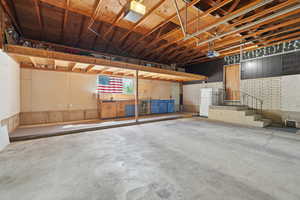 Garage featuring a garage door opener and freestanding refrigerator