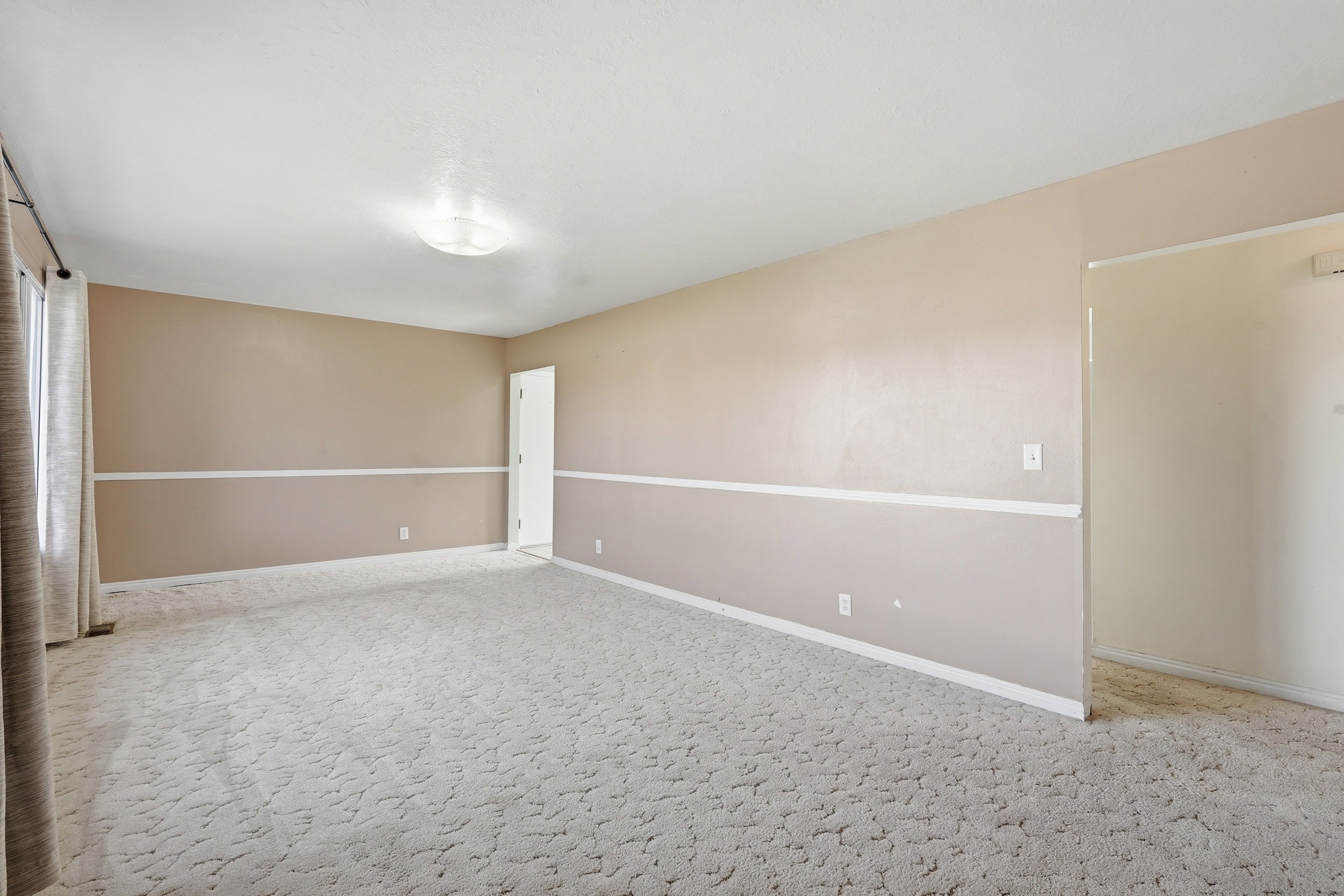 Unfurnished room featuring light carpet
