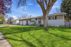 Ranch-style house with an attached garage, driveway, and a chimney