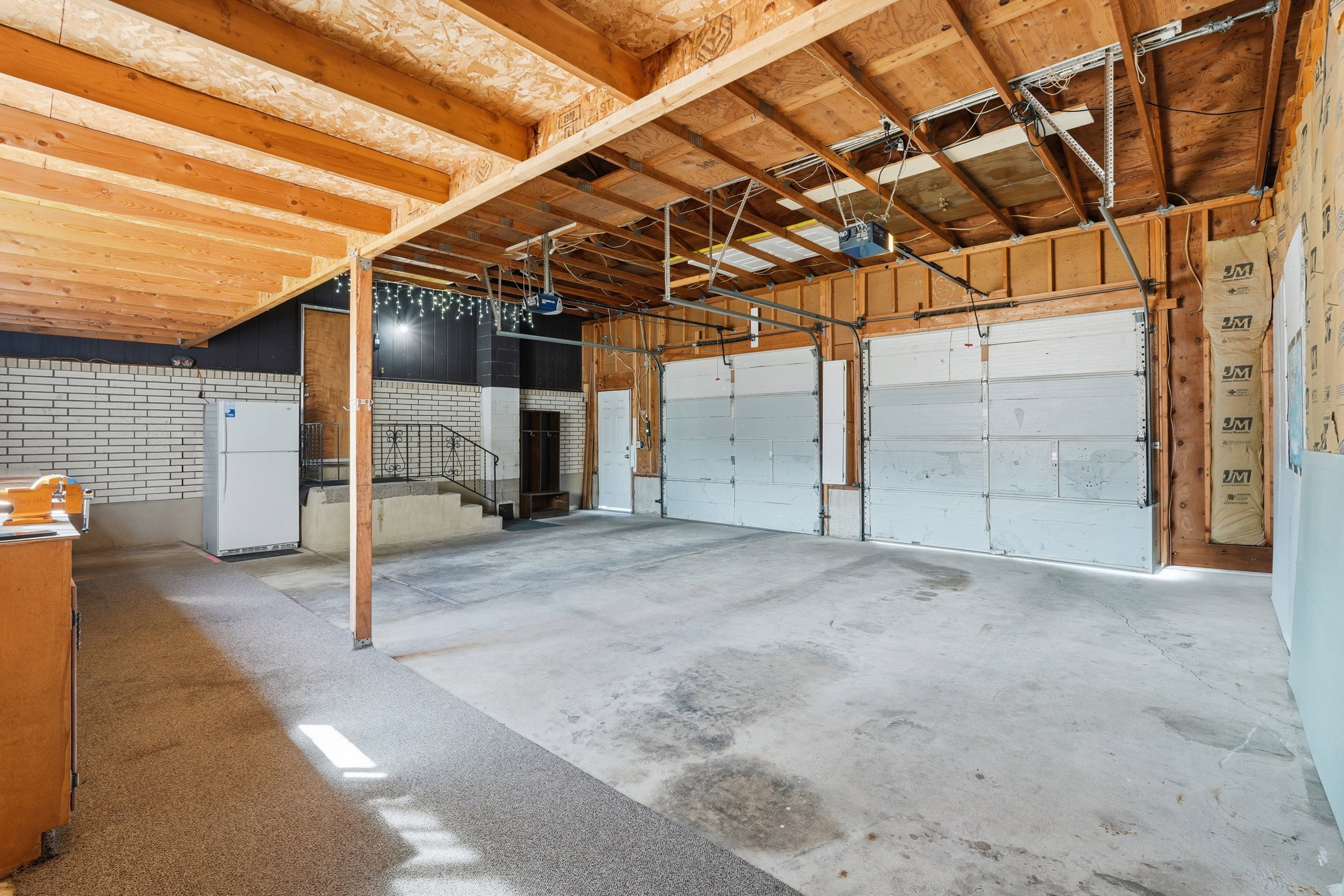 Garage featuring freestanding refrigerator and a garage door opener