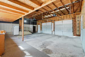 Garage featuring freestanding refrigerator and a garage door opener