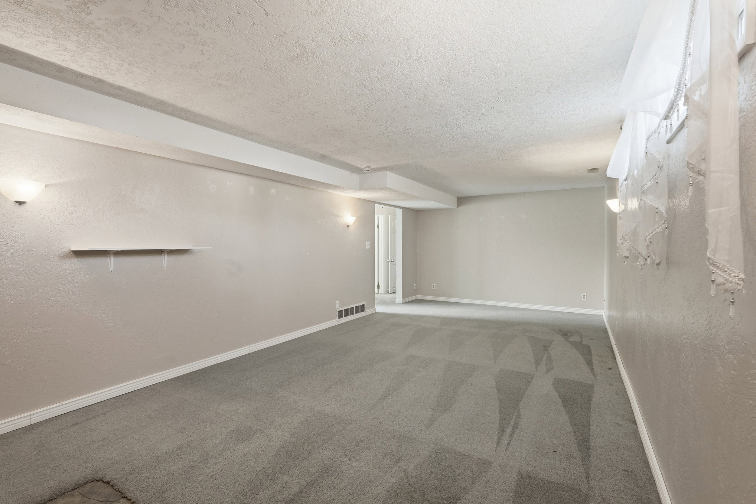 Finished basement featuring a textured ceiling and light colored carpet