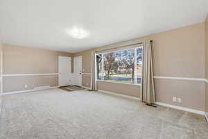 Spare room with light colored carpet and baseboards