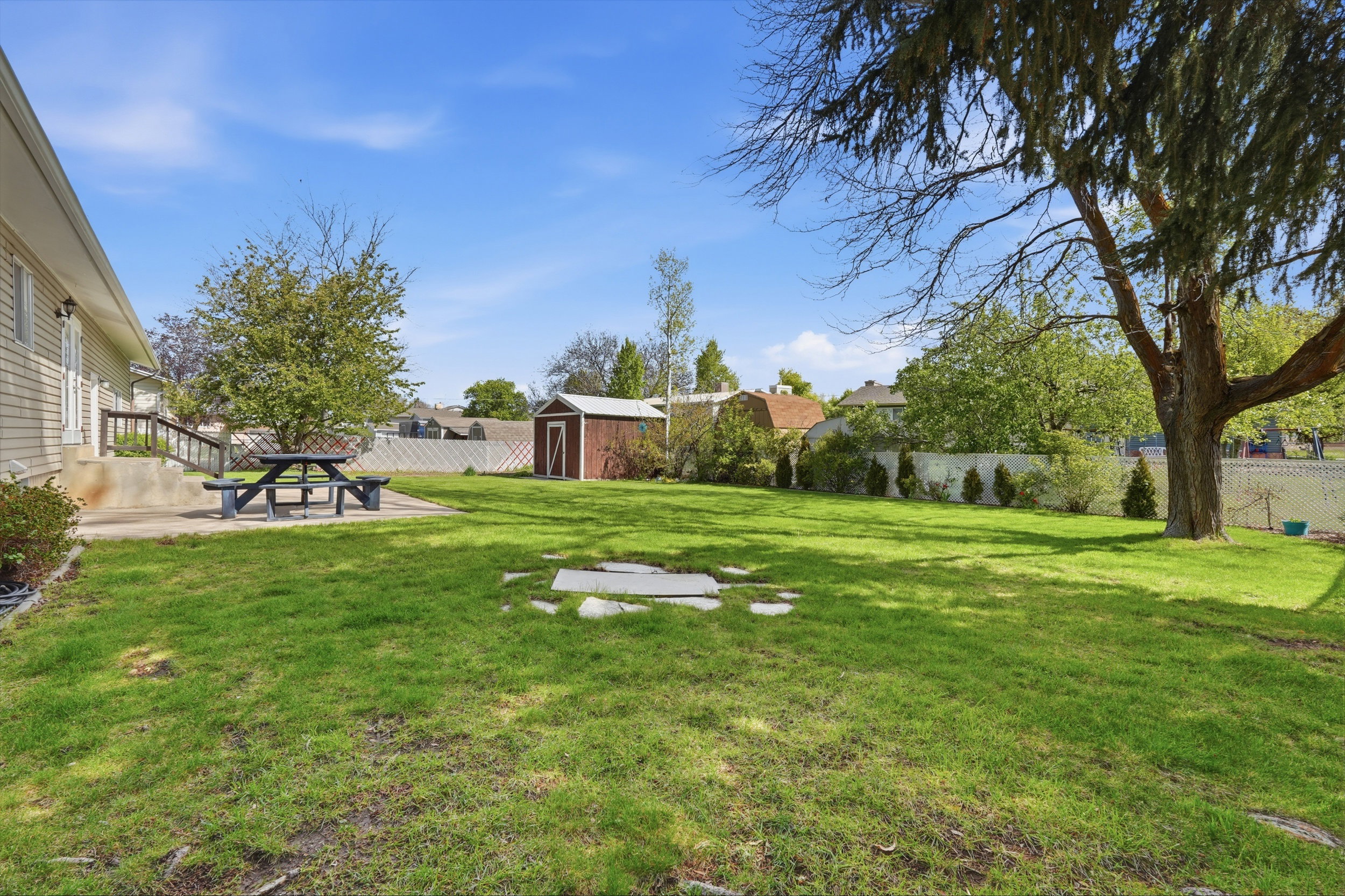 Fenced backyard featuring a shed and a patio