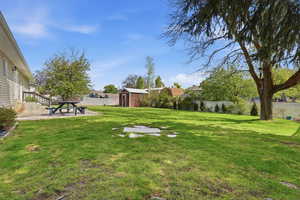 Fenced backyard featuring a shed and a patio