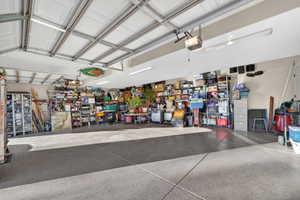 Two-car garage featuring a gray epoxy-coated floor, automatic overhead doors, and fluorescent lighting