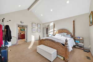 Vaulted ceiling with exposed beam, recessed lighting, and soft neutral wall tones